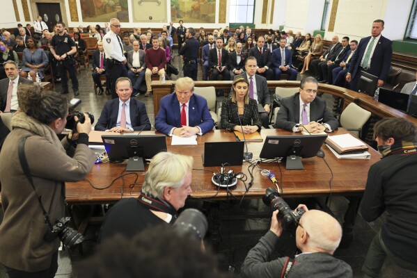 FILE - Former President Donald Trump, center, sits in the courtroom before the start of closing arguments in his civil business fraud trial at New York Supreme Court, Jan. 11, 2024, in New York. A New York judge has ruled against Donald Trump Friday, Feb. 16, imposing a $364 million penalty over what the judge said was a yearslong scheme to dupe banks and others with financial statements that inflated the former president’s wealth. Trump also has been barred from serving as an officer or director of any New York corporation for three years. However, the judge backed away from an earlier ruling that would have dissolved the former president’s companies. (Michael Santiago/Pool Photo via AP)