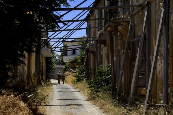 United Nations Peacekeepers walk inside the U.N.-controlled buffer zone in the center of Cyprus' divided capital, Nicosia, Thursday, June 6, 2024. Fifty years after war cleaved Cyprus along ethnic lines, tensions are rekindling along the 180-kilometer-long buffer zone separating Turkish Cypriots from Greek Cypriots. It's another potential source of instability in an already tumultuous region. (AP Photo/Petros Karadjias)