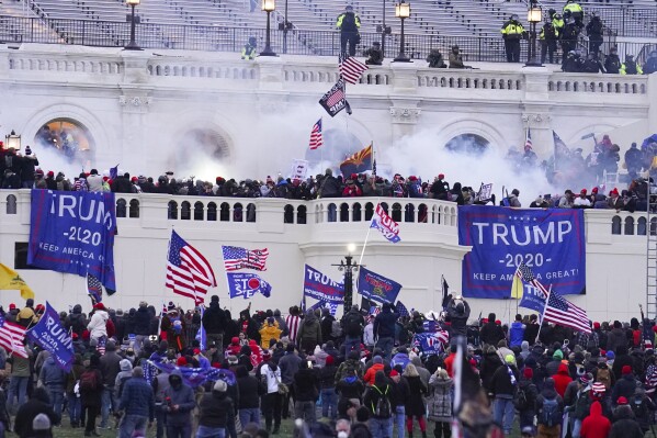 FILE - Rioters at the U.S. Capitol on Jan. 6, 2021, in Washington. A former Virginia police officer who stormed the U.S. Capitol has received a reduced prison sentence of six years. Former Rocky Mount Police Sgt. Thomas Robertson's resentencing on Wednesday makes him one of the first beneficiaries of a recent U.S. Supreme Court ruling that limited the government’s use of a federal obstruction law. (AP Photo/John Minchillo, File)