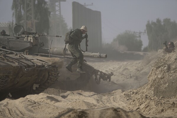 An Israeli soldier dismounts from his tank near the Israel-Gaza border in southern Israel, Friday, July 12, 2024. (AP Photo/Tsafrir Abayov)