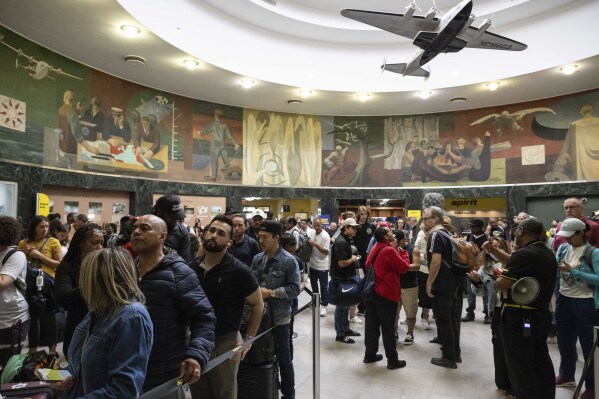 Customers wait in line at departure area for Spirit Airlines at LaGuardia Airport, Friday, July 19, 2024, in New York. (AP Photo/Yuki Iwamura)