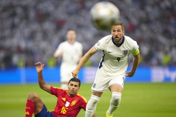 England's Harry Kane, right, and Spain's Rodri eye the ball during the final match between Spain and England at the Euro 2024 soccer tournament in Berlin, Germany, Sunday, July 14, 2024. (AP Photo/Manu Fernandez)