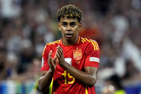 Spain's Lamine Yamal is substituted during a semifinal match between Spain and France at the Euro 2024 soccer tournament in Munich, Germany, Tuesday, July 9, 2024. Left Spain's Rodri. (AP Photo/Hassan Ammar)
