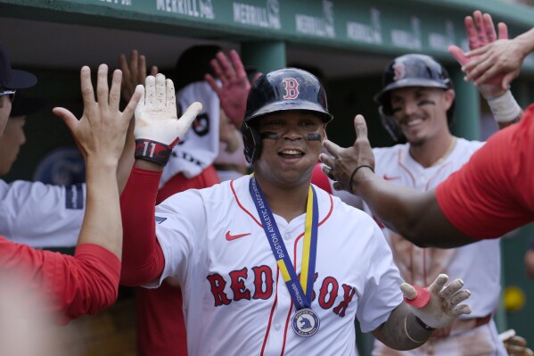 Boston Red Sox's Rafael Devers celebrates in the dugout with teammates after scoring on his two-run home in the first inning of a baseball game against the Kansas City Royals, Sunday, July 14, 2024, in Boston. (AP Photo/Steven Senne)