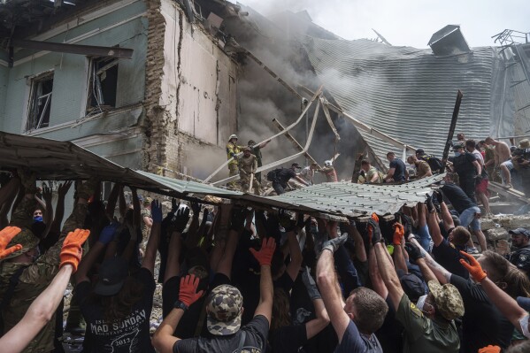 Rescuers work together to clear debris during a search operation for survivors at the Okhmatdyt children's hospital that was hit by a Russian missile, in Kyiv, Ukraine, July 8, 2024. (AP Photo/Evgeniy Maloletka)