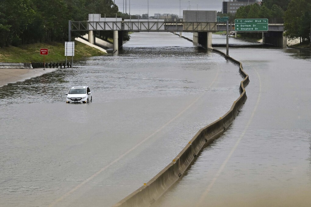 FILE - A vehicle is stranded on flooded Interstate 10 after Hurricane Beryl dumped rain, Monday, July 8, 2024, in Houston. As the city slowly struggles to recover after Hurricane Beryl left millions without power, experts say it's time to rethink how cities are preparing for and responding to weather disasters. (AP Photo/Maria Lysaker, File)