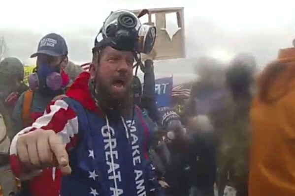 In this image from U.S. Capitol Police video, released and annotated by the Justice Department in the sentencing memorandum, Christopher Quaglin, appears on police body-worn camera footage at the U.S. Capitol on Jan. 6, 2021, in Washington. Quaglin, a New Jersey electrician who repeatedly attacked police officers during the siege at the U.S. Capitol has been sentenced to 12 years in prison. (Justice Department via AP)