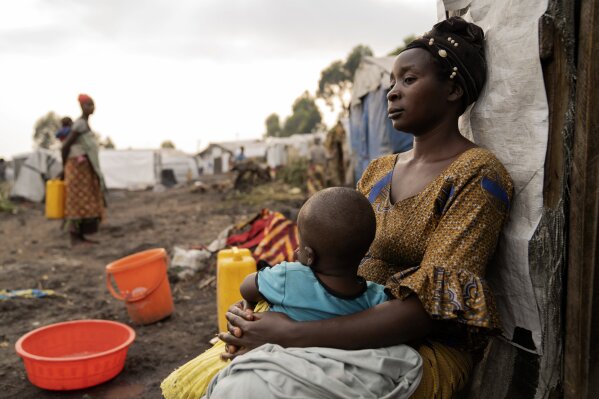 A mother Mapendo with her child sits outside her tent at a refugee camp on the outskirts of Goma, Democratic Republic of the Congo, Thursday, July 11, 2024. The top U.N. official in Congo on Monday, July 8, welcomed a two-week humanitarian cease-fire in its mineral-rich east, where she said violence has reached "alarming levels" and risked provoking a wider regional conflict. (AP Photo/Moses Sawasawa)
