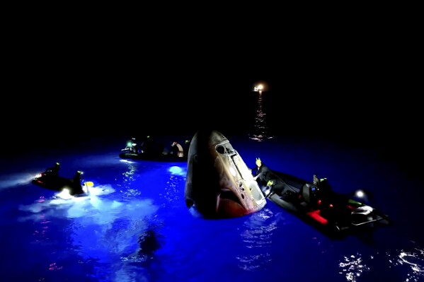 This image made from SpaceX video shows its capsule, center, carrying tech entrepreneur Jared Isaacman with his crew after it reached the Gulf of Mexico near Florida's Dry Tortugas early Sunday, Sept. 15, 2024. (SpaceX via AP)