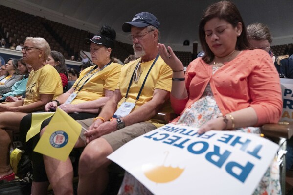 People pray before the start of the Moms for Liberty National Summit in Washington, Saturday, Aug. 31, 2024. (AP Photo/Jose Luis Magana)