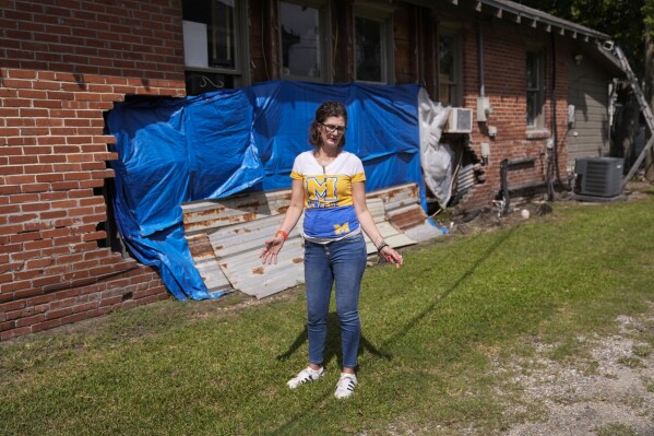 Terra Hillman shows the exterior damage that still exists to her home, caused by Hurricanes Laura and Delta four years ago, in Lake Charles, La., Tuesday, Sept. 3, 2024. (AP Photo/Gerald Herbert)