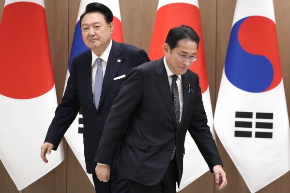 South Korean President Yoon Suk Yeol, left, and Japanese Prime Minister Fumio Kishida, right, walk to their chairs during a meeting at the Presidential Office in Seoul, South Korea, Friday, Sept. 6, 2024. (AP Photo/Lee Jin-man, Pool)