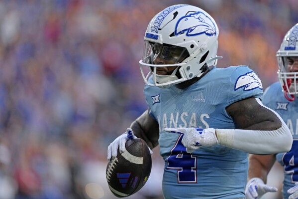 Kansas running back Devin Neal (4) celebrates with after scoring a touchdown during the first half of an NCAA college football game against Lindenwood Thursday, Aug. 29, 2024, at Children's Mercy Park in Kansas City, Kan. (AP Photo/Charlie Riedel)