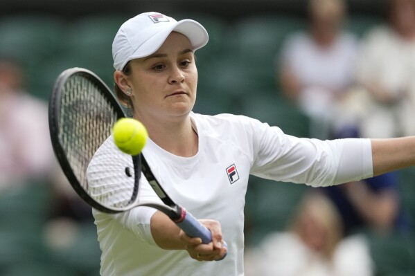 Australia's Ash Barty plays a forehand return during her invitation doubles match with compatriot Casey Dellacqua against Andrea Petkovic of Germany and Magdelena Rybarikova of Slovakia at the Wimbledon tennis championships in London, Wednesday, July 10, 2024. (AP Photo/Kirsty Wigglesworth)