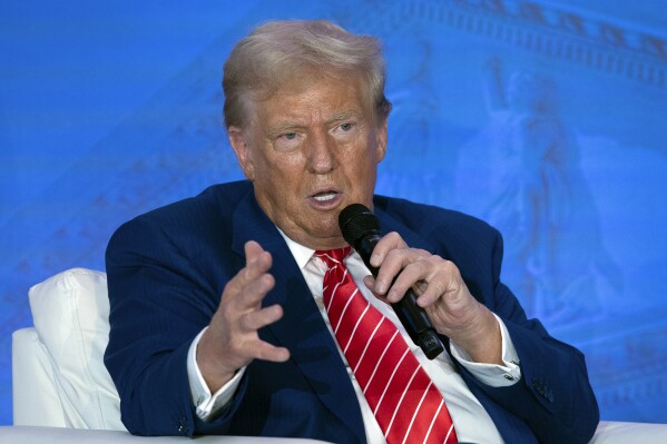 Republican presidential nominee former President Donald Trump speaks with Moms for Liberty co-founder Tiffany Justice during an event at the group's annual convention in Washington, Friday, Aug. 30, 2024. (AP Photo/Jose Luis Magana)