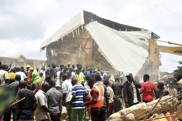 People and rescuers gather at the scene of a collapsed two-storey building in Jos, Nigeria, Friday, July, 12, 2024. At least 12 students have been killed after a school building collapsed and trapped them in northern Nigeria, authorities said on Friday. (AP Photos)