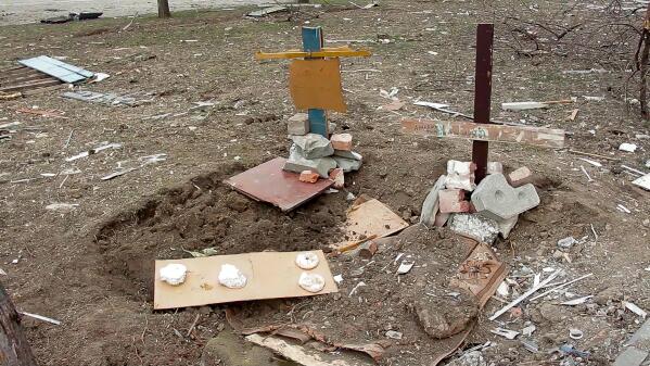 This March 26, 2022 image from video shows the makeshift graves of two women who were killed at 110 Mytropolytska St. in the Ukrainian city of Mariupol when a Russian tank opened fire on their building on March 11. Residents say the city was full of makeshift graves such as these, with thousands killed during the Russian siege. (AP Photo)