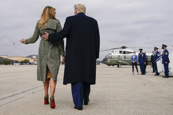 President Donald Trump walks with first lady Melania Trump after speaking to reporters before boarding Air Force One for a day of campaign rallies in Michigan, Wisconsin, and Nebraska, Tuesday, Oct. 27, 2020, at Andrews Air Force Base, Md. The first lady will be campaigning in Pennsylvania. (AP Photo/Evan Vucci)