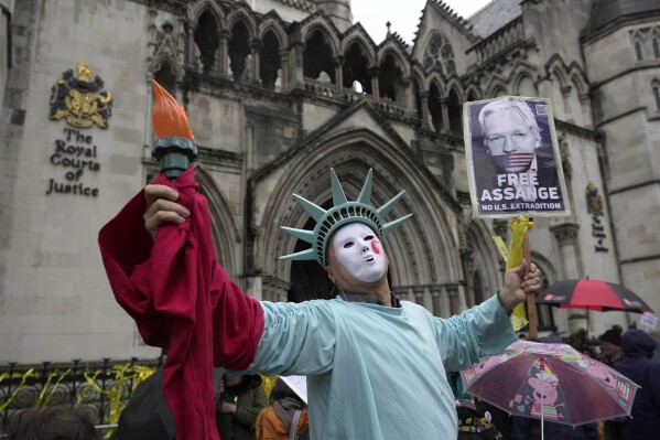 A protester stands outside the Royal Courts of Justice in London, Wednesday, Feb. 21, 2024. Julian Assange's lawyers are on their final U.K. legal challenge to stop the WikiLeaks founder from being sent to the United States to face spying charges. The 52-year-old has been fighting extradition for more than a decade, including seven years in self-exile in the Ecuadorian Embassy in London and the last five years in a high-security prison. (AP Photo/Kin Cheung)