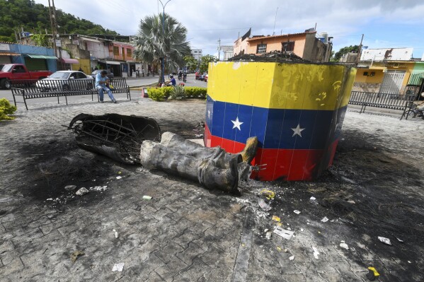 A destroyed statue of the late Venezuelan President Hugo Chavez lies next to its base in Valencia, Venezuela, Tuesday, July 31, 2024, the day after people protested the official election results that certified Chavez's protege, current President Nicolas Maduro, as the winner. (AP Photo/Jacinto Oliveros)