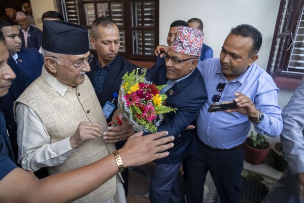 Khadga Prasad Oli, left, the chairman of the Communist Party of Nepal leaves his residence to meet his supporters after being appointed as Prime Minister, in Kathmandu, Nepal, Sunday, July 14, 2024. The leader of the Nepal's largest communist party, Khadga Prasad Oli, was named the Himalayan nation's new prime minister on Sunday following the collapse of a previous coalition government. (AP Photo/Niranjan Shrestha)