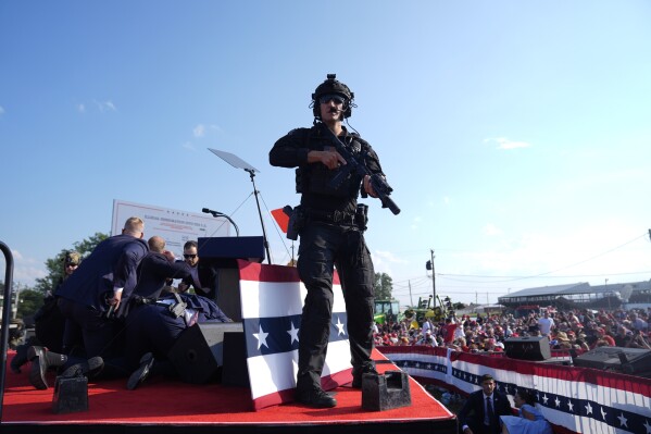 Republican presidential candidate former President Donald Trump is surrounded by U.S. Secret Service agents on stage at a campaign rally, Saturday, July 13, 2024, in Butler, Pa. (AP Photo/Evan Vucci)