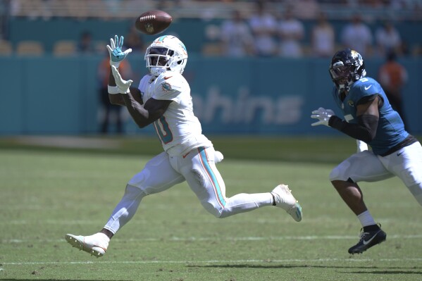 Miami Dolphins wide receiver Tyreek Hill (10) grabs a pass for a touchdown during the second half of an NFL football game against the Jacksonville Jaguars, Sunday, Sept. 8, 2024, in Miami Gardens, Fla. (AP Photo/Wilfredo Lee)