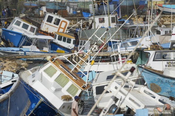 A fisherman looks at vessels damaged by Hurricane Beryl at the Bridgetown Fisheries in Barbados, July 1, 2024. (AP Photo/Ricardo Mazalan)