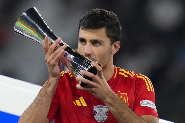 Spain's Rodri kisses his Best Player of the tournament trophy after the final match between Spain and England at the Euro 2024 soccer tournament in Berlin, Germany, Sunday, July 14, 2024. Spain won 2-1. (AP Photo/Manu Fernandez)