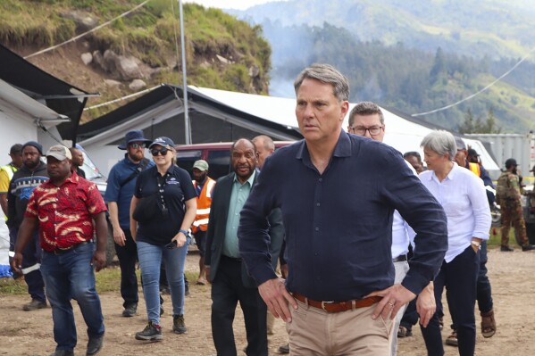 In this photo released by IOM- PNG- Australia's Deputy Prime Minister Richard Maples walks around the sight of landslide at Yambali village in the Papua New Guinea highlands Thursday, June 20, 2024. Australia will provide a further $1.3 million to support reconstruction efforts in Papua New Guinea after last month's deadly landslide. The South Pacific island nation off Australia's northern coast is still struggling with the aftermath of the disaster in Enga province in its mountainous interior. (David Kuna/IOM - PNG via AP)