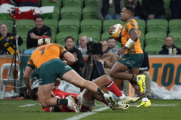 Australia's Filipo Daugunu, right, races to score a try against Wales after getting a pass from teammate Fraser McReight, left, during their rugby union test match in Melbourne, Saturday, July 13, 2024. (AP Photo/Asanka Brendon Ratnayake)