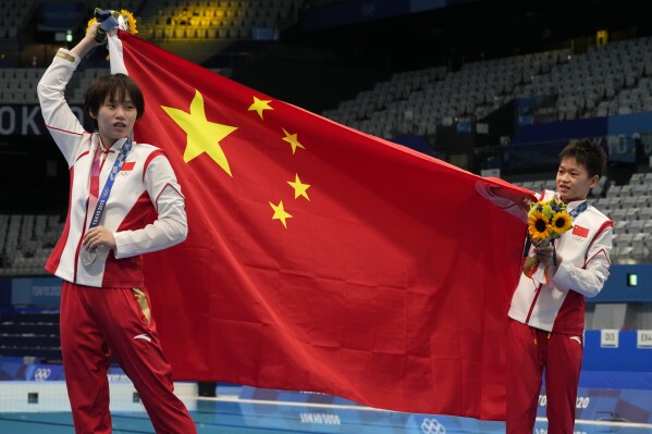 FILE - Chen Yuxi of China, left, silver medal and Quan Hongchan of China, gold medal react after winning gold medal in women's diving 10m platform final at the Tokyo Aquatics Centre at the 2020 Summer Olympics, on Aug. 5, 2021, in Tokyo, Japan. Chinese divers are focused on winning all eight gold medals at the Paris Olympics. The Chinese have dominated the sport for decades but have never won every gold medal in diving in a single Olympics. (AP Photo/Dmitri Lovetsky, File)