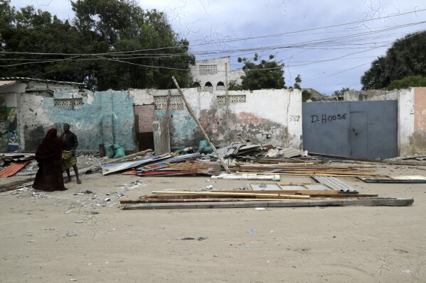 People stand on the beach following an attack in Mogadishu, Somalia, Saturday Aug. 3, 2024. Police in Somalia said Saturday that many people died and several others were wounded in an attack on a beach hotel in the capital, Mogadishu, the previous evening. (AP Photo/Farah Abdi Warsameh)