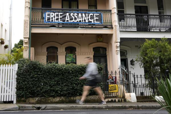 A pedestrian walks past a house with a sign in support of WikiLeaks founder Julian Assange in Sydney, Australia, Monday, June 20, 2022. Australian Prime Minister Anthony Albanese on Monday rejected calls for him to publicly demand the United States drop its prosecution of WikiLeaks founder and Australian citizen Julian Assange.(AP Photo/Mark Baker)