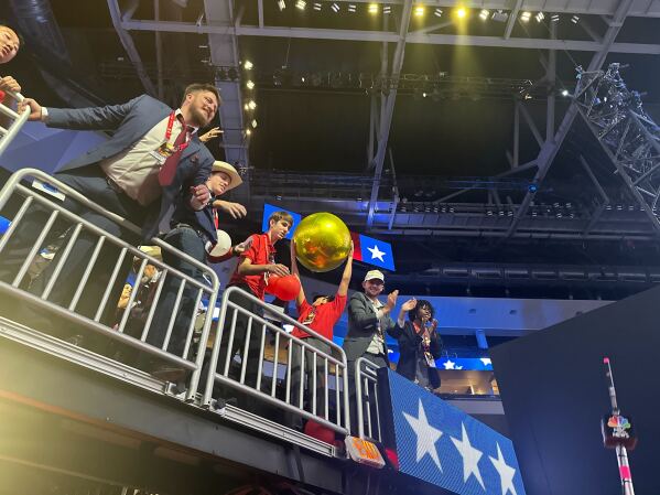 A delegate grabs a gold balloon at the Republican National Convention in Milwuakee, Wisconsin, on July 18, 2024. (AP Photo / Meg Kinnard)