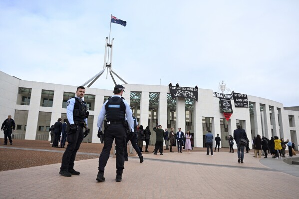 Pro-Palestinian protesters hang banners from the top of Parliament House in Canberra, Australia, Thursday, July 4, 2024. Pro-Palestinian protesters breached security at Australia’s Parliament House to unfurl banners from the roof on Thursday as a senator quit the government over its direction on the Gaza war. (Lukas Coch/AAP Image via AP)