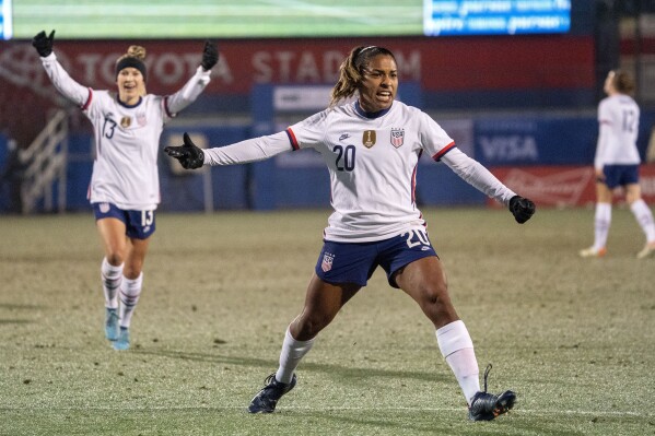 FILE - United States forward Catarina Macario (20) and midfielder Ashley Sanchez (13) celebrate Macario's goal during the first half of a She Believes Cup soccer match against Iceland at Toyota Stadium, Wednesday, Feb. 23, 2022 in Frisco, Texas. Forward Catarina Macario won't be able to train for the Olympics because of irritation in her right knee, U.S. coach Emma Hayes announced on Friday, July 12, 2024. (AP Photo/Jeffrey McWhorter, File)