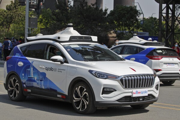 FILE - Baidu Apollo Robotaxis move on a street at the Shougang Park in Beijing, May 2, 2021. A driverless ride-hailing car operated by Chinese tech giant Baidu hit a pedestrian, and people on social media are taking the carmaker's side, because the person was reportedly crossing against the light. (AP Photo/Andy Wong, File)