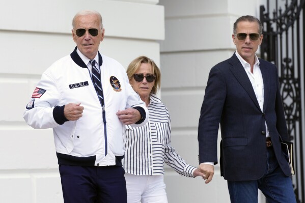 President Joe Biden, from left, walking with his sister Valerie Biden Owens and his son Hunter Biden, shows off his Team USA jacket as he walks toward Marine One on the South Lawn of the White House in Washington, Friday, July 26, 2024, en route to Camp David for the weekend. (AP Photo/Susan Walsh)