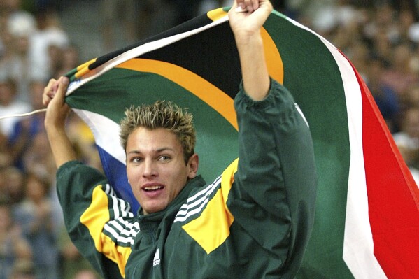 FILE - Jacques Freitag of South Africa waves his national flag after he won the Men's high jump event at the World Athletics Championships, at the Stade de France in Saint Denis, north of Paris, Monday, Aug. 25, 2003. Local media is reporting that South African police have discovered the body of former high jump world champion Jacques Freitag after he went missing last month. The reports said the 42-year-old, who won the 2003 world title in Paris and competed at the 2004 Olympics, had been shot. (AP Photo/Thomas Kienzle, File)