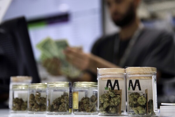 FILE - A cashier rings up a marijuana sale, July 1, 2017, at a cannabis dispensary in Las Vegas. (AP Photo/John Locher, File)