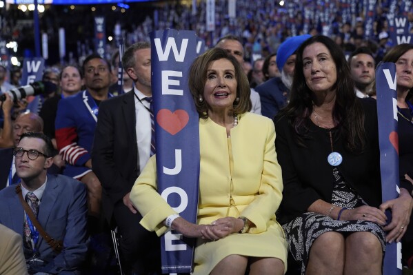 Rep. Nancy Pelosi, D-Calif., holds a sign as President Joe Biden speaks during the Democratic National Convention Monday, Aug. 19, 2024, in Chicago. (AP Photo/Paul Sancya)