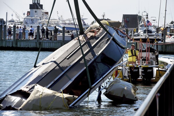 A capsized boat with a damaged hull is lifted out of the water by a Sea Tow Salvage Response Unit and Eric's Towing at Saybrook Point in Old Saybrook, Conn. on Tuesday, Sept. 3, 2024. (Arnold Gold/Hearst Connecticut Media via AP)