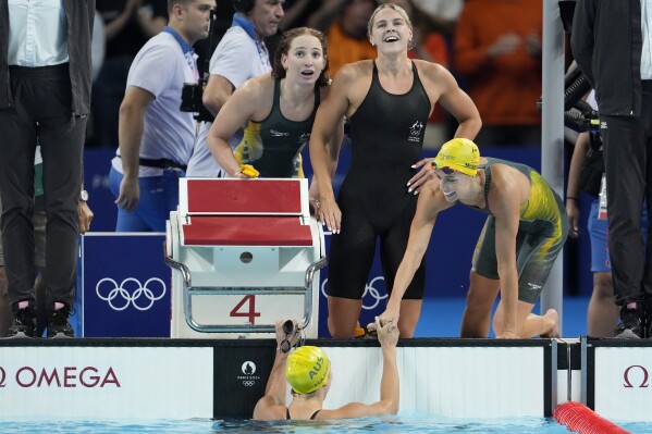 Swimmers from Australia celebrate after winning the women's 4x100-meter freestyle relay final at the 2024 Summer Olympics, Saturday, July 27, 2024, in Nanterre, France. (AP Photo/Matthias Schrader)