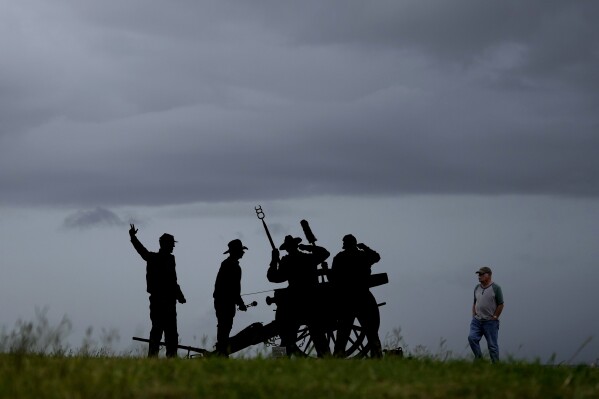 Leo Cardin walks past a Confederate Artillery Battery display as he watches storm clouds roll in ahead of Beryl, Sunday, July 7, 2024, in Port Lavaca, Texas. (AP Photo/Eric Gay)