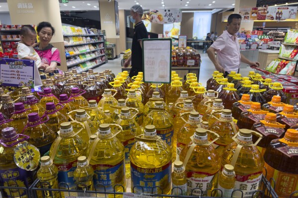 Shoppers pass by cooking oil products at a supermarket in Beijing, Wednesday, July 10, 2024. China's authorities said they were investigating food safety concerns in cooking oils after an investigative report from local media revealed that tankers carrying soybean oil from a major state-owned company were also used to carry a form of coal. (AP Photo/Ng Han Guan)