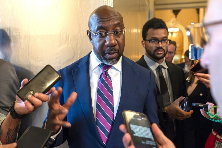 FILE - Sen. Raphael Warnock, D-Ga., speaks with reporters, Sept. 28, 2023, in Washington. Senior Democratic figures rallied publically around President Joe Biden on Sunday, June 30, 2024, amid private angst within the party about Thursday's debate performance. Warnock said during NBC's "Meet The Press," there had been "more than a few Sundays, when I wish I had preached a better sermon, but after the sermon was over it was my job to embody the message, to show up for the people that I serve. And that's what Joe Biden has been doing his entire life." (AP Photo/Alex Brandon, File)