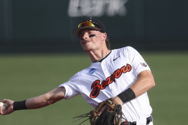FILE - Oregon State infielder Travis Bazzana plays during an NCAA regional baseball game against Tulane on May 31, 2024, in Corvallis, Ore. Bazzana was taken by the Cleveland Guardians on Sunday, July 14, 2024, with the top pick in Major League Baseball’s amateur draft. (AP Photo/Amanda Loman, File)