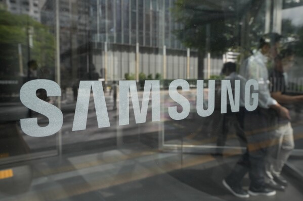 Employees walk past the logo of the Samsung Electronics Co. at its office in Seoul, South Korea, Wednesday, July 31, 2024. (AP Photo/Ahn Young-joon)