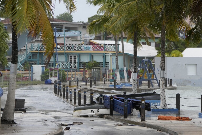 Boats lie capsized in a flooded street after Hurricane Beryl passed through St. Lawrence, Barbados, Monday, July 1, 2024. (AP Photo/Ricardo Mazalan)